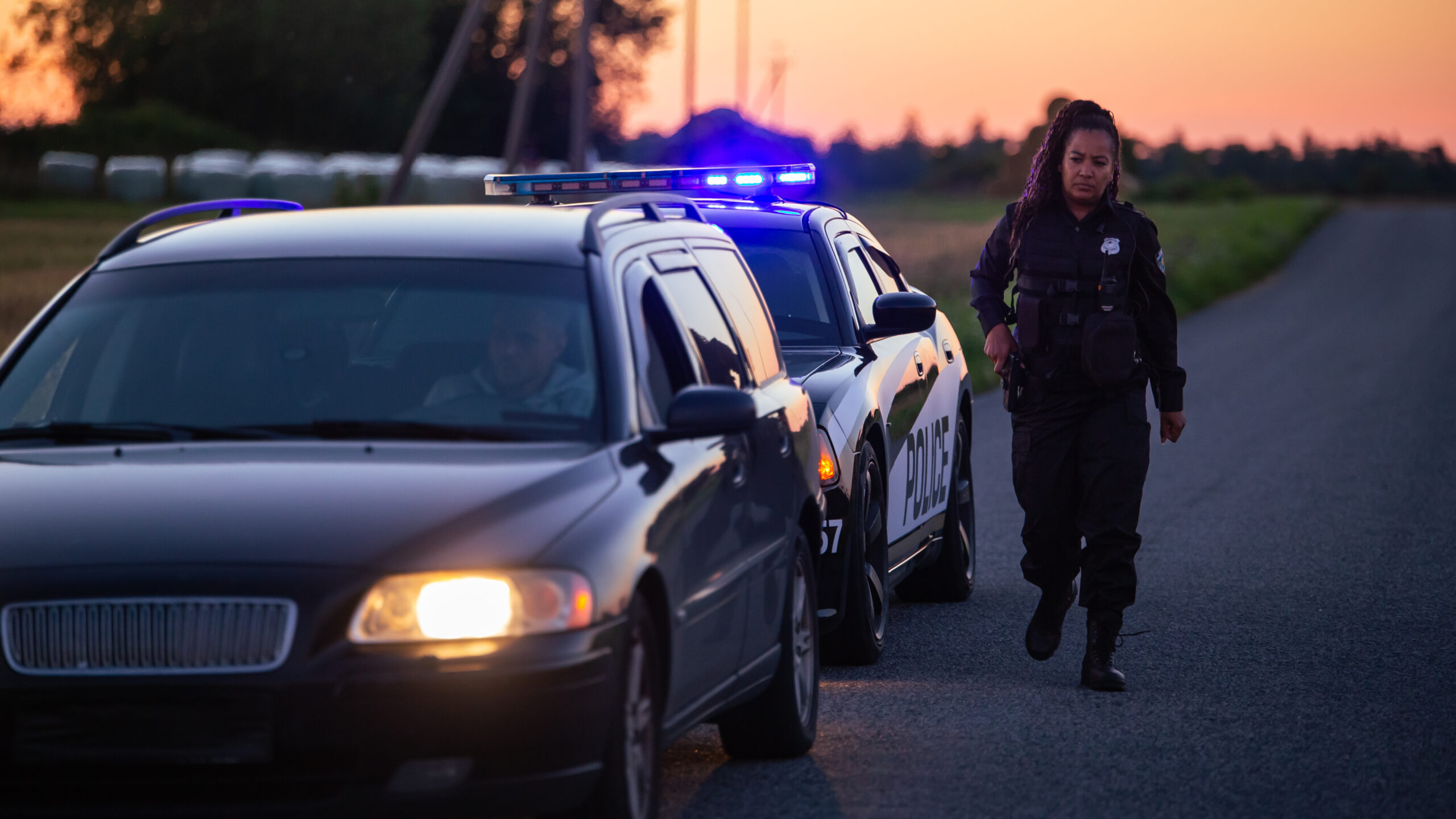 A female highway patrol office pulls over a vehicle.